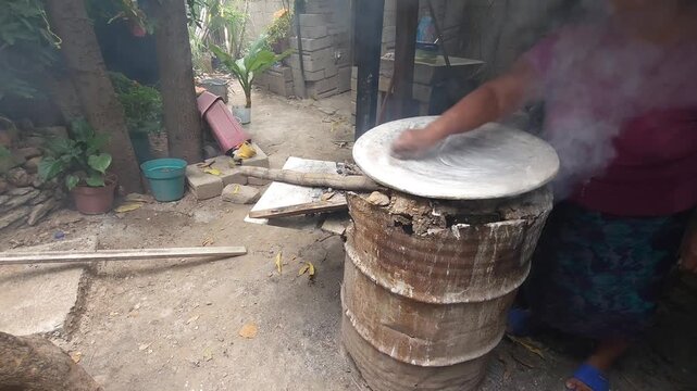 Woman Cleaning and Preparing Traditional Clay Comal with Lime Wash
