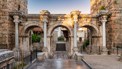 Fototapeta premium The ancient Roman Hadrian's Gate with its three arches and Corinthian columns standing in the historic Kaleici district of Antalya, Turkey during a sunny afternoon