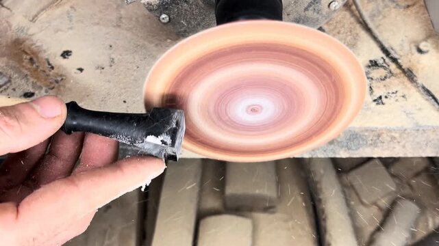 Close up of hands sanding a black chess piece