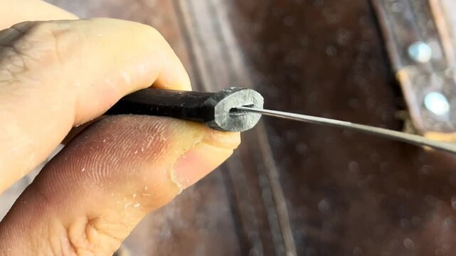 Crafter carefully fitting a metal tang into a handle