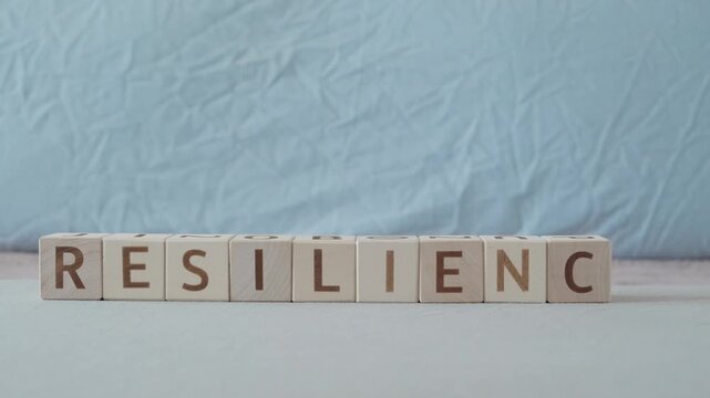resilience, motivational word, laying out  by hand from letters on wooden cubes, slow motion
