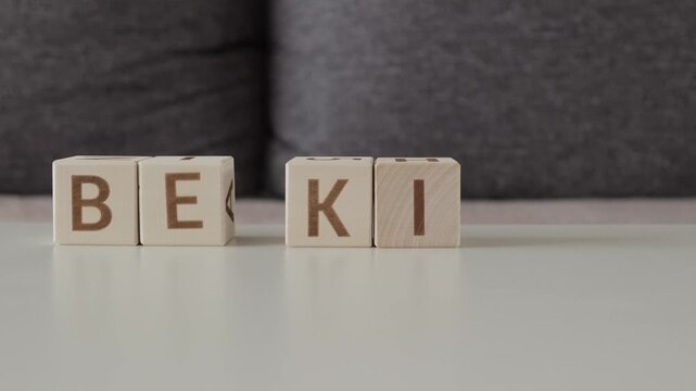 be kind, motivational phrase, laying out  by hand from letters on wooden cubes, slow motion
