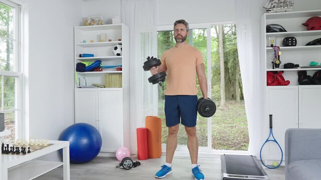 Dumbbells workout for healthy body. Man exercising at home with weights. Home workout dumbbells for fitness. Fitness man training arms with dumbbells. Dumbbells routine for home exercise.