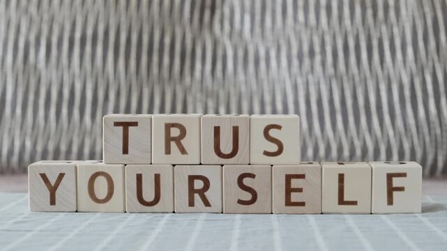 trust yourself, laying out  by hand from letters on wooden cubes, slow motion
