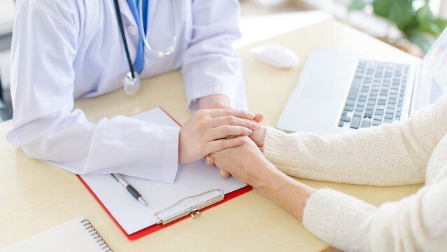 Asian female doctor holding caregiver hand senior patient woman symbolizing trust compassion emotional support quality elderly healthcare insurance rehabilitation assistance recovery wellness medical.
