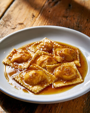 Delicious Pumpkin Ravioli with Brown Butter Sauce on Rustic Wooden Table