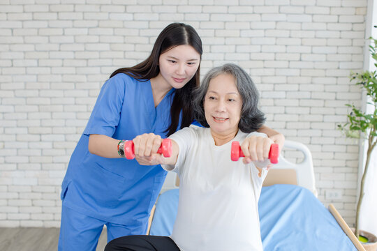 Asian female doctor physical therapist help senior woman rehabilitation posture therapy in healthcare clinic professional patient care elderly recovery support wellness quality medical services.