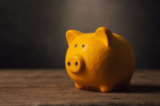 Piggy bank on wooden background with filter effect retro vintage style