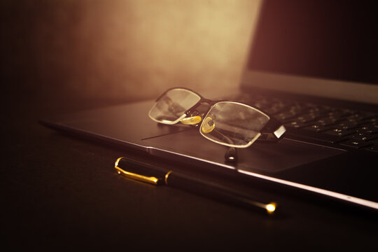 Glasses on laptop keyboard. Business and technology concept.