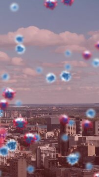 Animation of covid 19 cells floating over cityscape on pink background