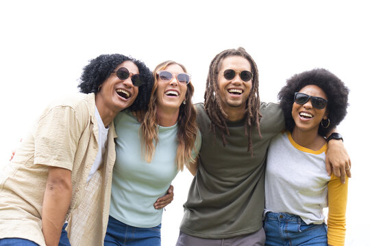 Diverse friends linking arms laughing leaning toward camera in set wearing sunglasses, watch, hoops