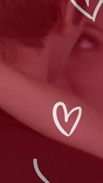 Animation of white hearts over caucasian couple wearing wedding clothes and dancing