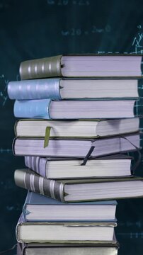 Pile of books and mathematical equations and graphs