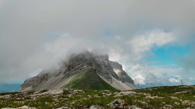 Thick fog rolls across rugged Dolomites summit near Passo Groste cable car station