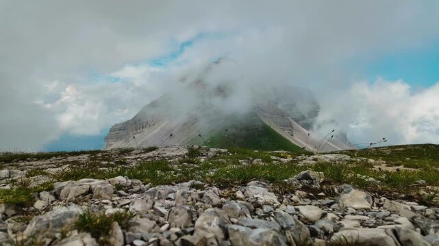 Time lapse clouds drift over jagged Dolomites peak seen from Passo Groste upper station
