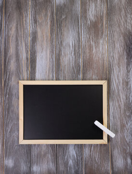 Empty black chalkboard with white chalk on wooden table. symbol of school, education, Knowledge Day, teacher's day, graduation, back to school concept. copy space. top view. template for design