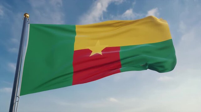 The flag of Cameroon waving against a cloudy blue sky.