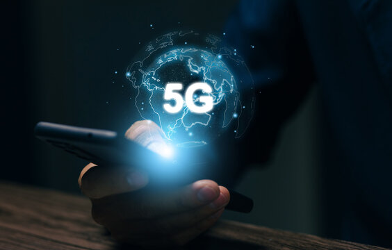 Business professional using smartphone with glowing 5G global network, illustrating high speed mobile connectivity, wireless communication, digital technology, and worldwide internet.