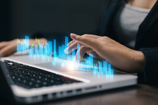 Business professional analyzing virtual stock charts on laptop, illustrating financial data, market trading, investment research, fintech technology, business analytics, and economic trends.