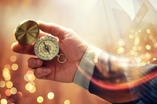 Double exposure businessman with vintage compass in a hand and skyscraper.  concept to make decision or choose direction