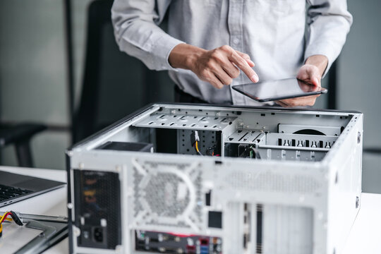 A computer technician fixes PC hardware in a professional engineering lab