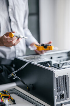 A computer technician fixes PC hardware in a professional engineering lab