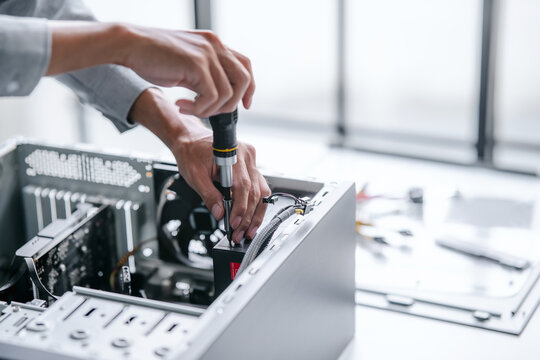 A computer technician fixes PC hardware in a professional engineering lab