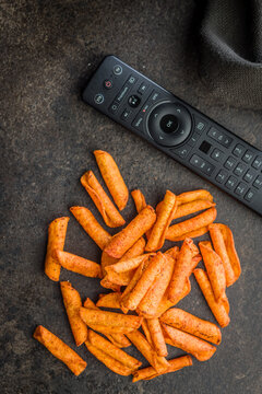 Spicy Crunchy Snack Sticks Next To TV Remote For Movie Night And Casual Couch Snacking