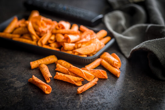 Crispy Spicy Taquitos Pile on Dark Surface Close-Up, Mexican Rolled Corn Snack