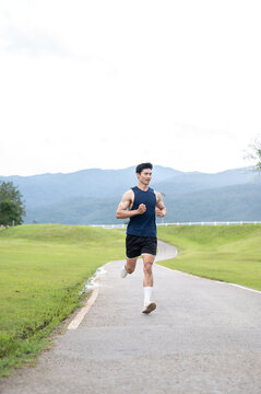 Athletic Asian Man Sprinting on Outdoor Road