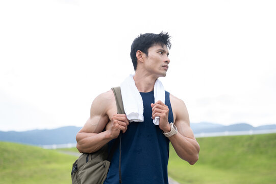 Athletic Asian Man Walking with Backpack After Workout