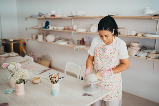 Artisan woman crafting handmade pottery in her studio