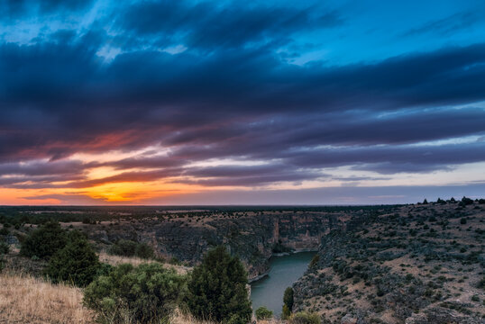 Dramatic cloudy sunset over a deep river canyon