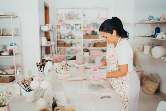 Female artisan hand building a ceramic plate
