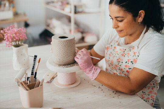 Female latina potter working on ceramics in her studio
