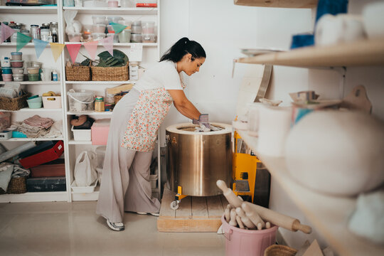 Female potter carefully loading a ceramic kiln