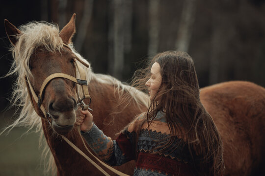 A young girl in a cozy patterned sweater and brown pleated skirt is