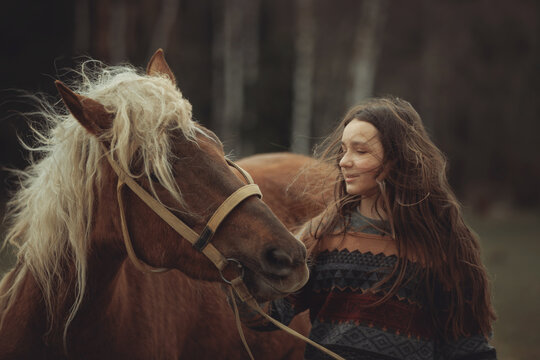 A young girl in a cozy patterned sweater and brown pleated skirt is