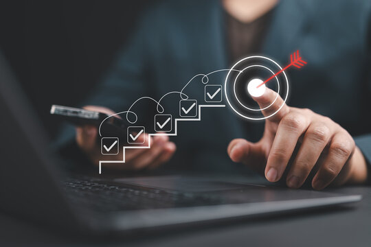 Businessman planning goals with digital checklist and target strategy, success achievement steps, corporate project management, performance tracking, and strategic growth objectives