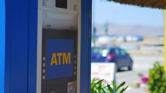 A close-up shot of an ATM sign in a public space, highlighting the logo on a blue background in 4K slow motion 60fps