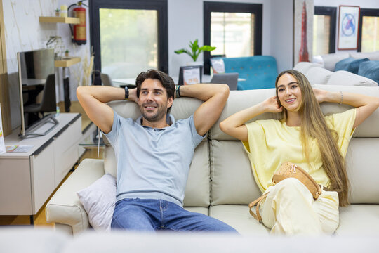 Couple relaxing on sofa in furniture showroom