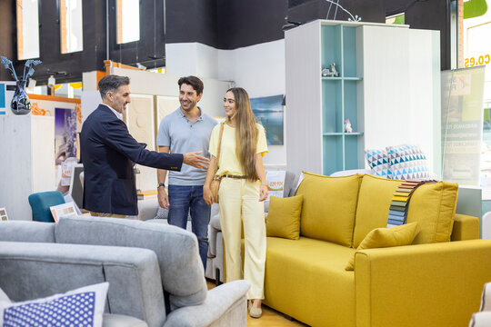 Salesman presenting furniture options to happy couple