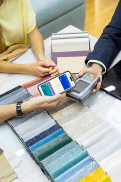 Client completing contactless payment for fabric samples