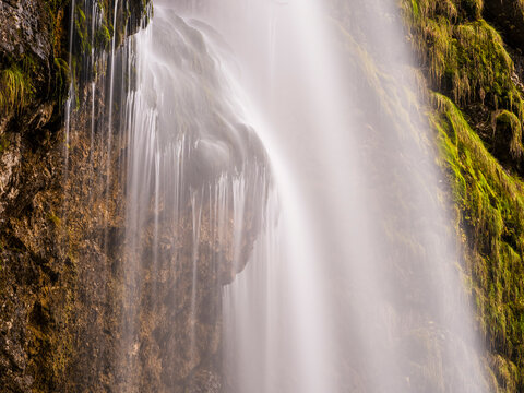 Goriuda waterfall cascades down a mossy cliff in this serene nature landscape, representing fine tourism and outdoor exploration in Goriuda waterfall, Julian Alps, Chiusaforte, Friuli, Italy.