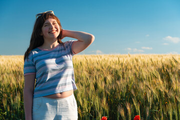 Happy teenage girl enjoying sunny day in wheat field