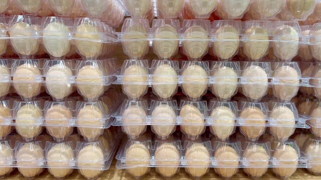 Egg Cartons Stacked on Supermarket Refrigerated Shelf &ndash; Assorted Chicken Eggs in Various Packaging Sizes, Including White and Brown Eggs