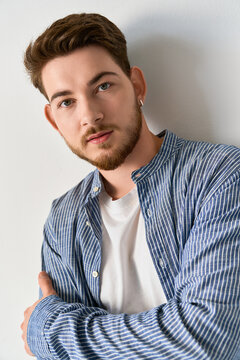 Stylish young man in casual attire exuding confidence in a modern studio setting