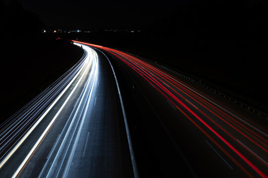 Eine Autobahn in der Nacht mit Langzeitbelichtung von einer Br&uuml;cke fotografiert