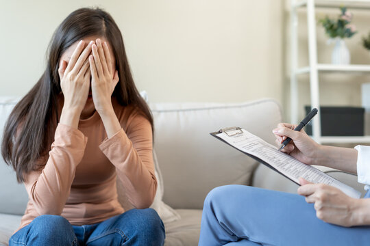 woman cover face felling sad from health problems. psychiatrist is recording the patient's condition for treatment. encouragement, love and family problem, bipolar , depression
