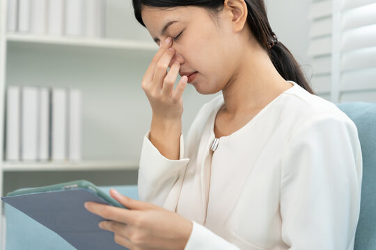 Eye problems, Asian women use hand cover eyes due to eye irritation, eye rubbing, dry, eye pain after look tablet long time in the dark, headache, blurred vision, photophobia, small words